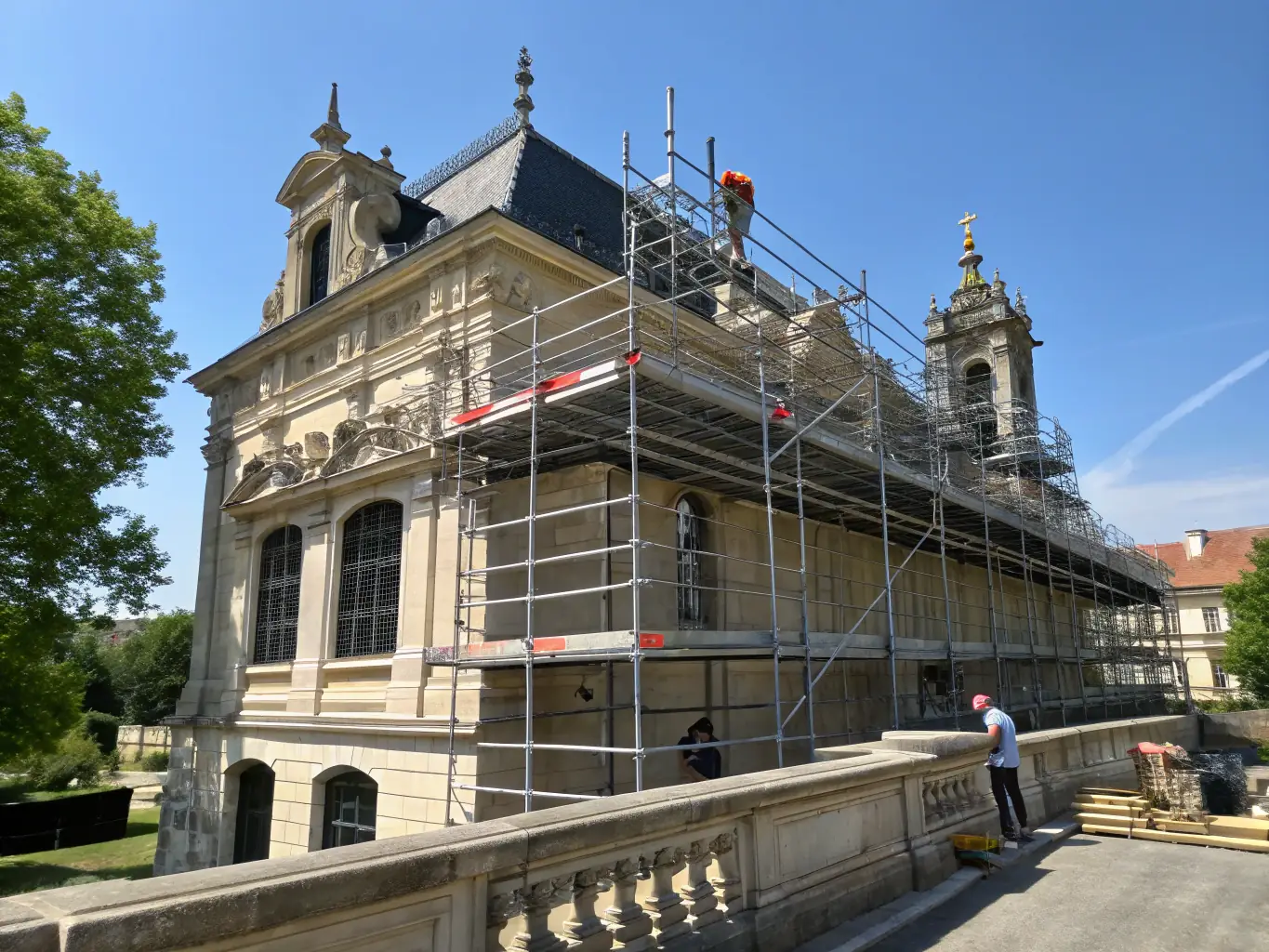 A photograph of a historic building undergoing renovation, with scaffolding and workers carefully restoring the facade, preserving its original architectural details.