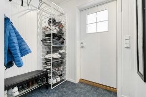 A walk in closet with a coat rack and shoes